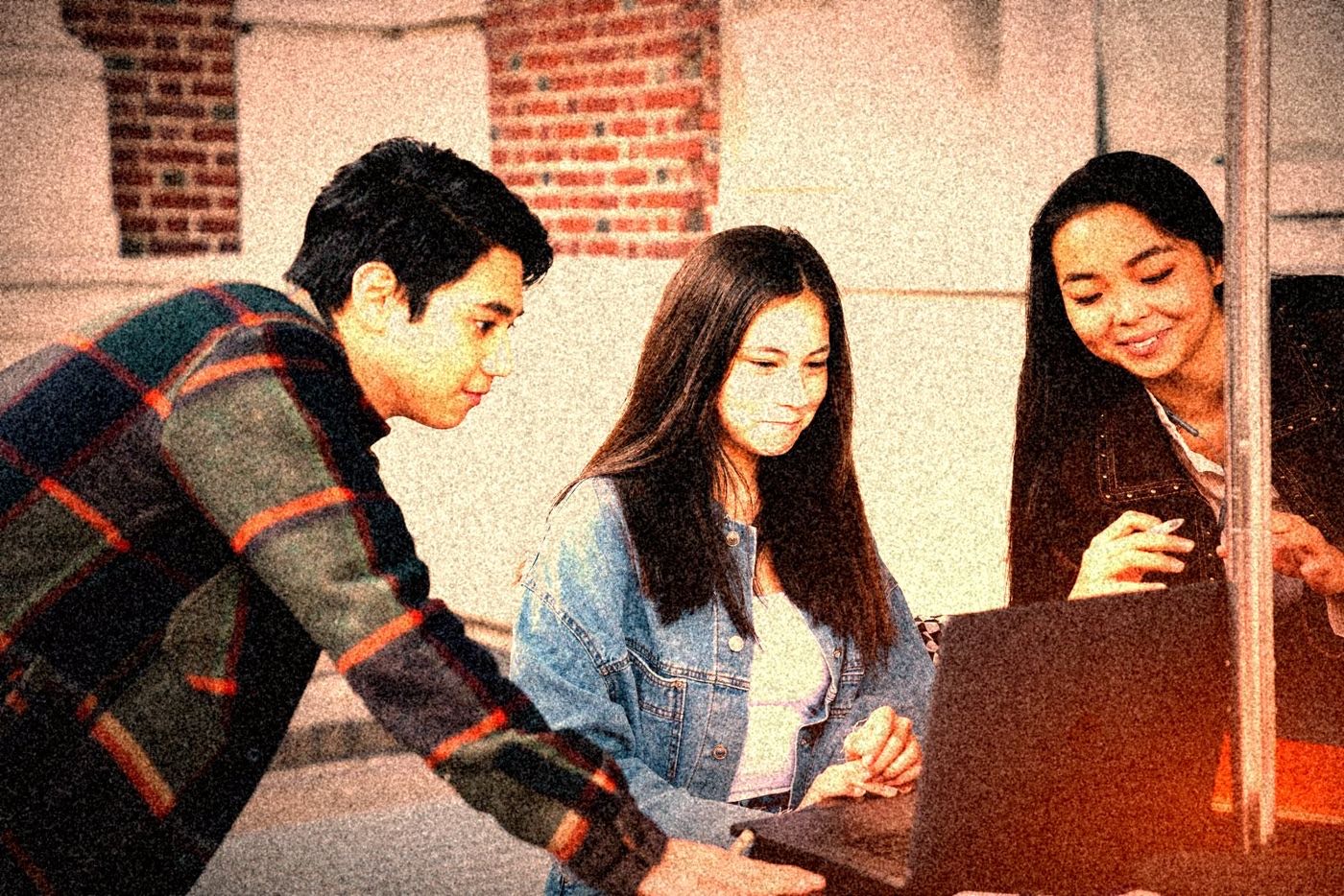 Trois étudiants qui travaillent ensemble autour d'un ordinateur portable.